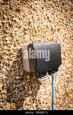 Inländische im Freien elektrische Steckdose Wasserdichte Box mit blauem Kabel läuft. Stockfoto