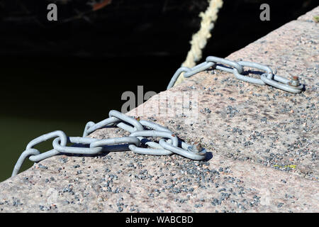 Autoreifen hängen mit Stahl Ketten an der Wand, auf die Boote verankert werden können. Die Reifen gibt es Boote und Yachten vor Kratzern zu schützen. Stockfoto