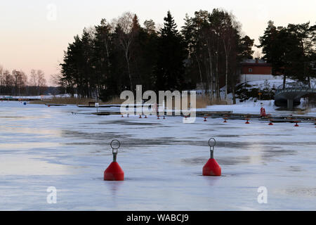 Zwei rote Bojen auf der Oberfläche der zugefrorenen Ostsee in Espoo, Finnland. Sie können sehen, die teilweise schmilzt das Eis und die wunderschöne Natur. Stockfoto