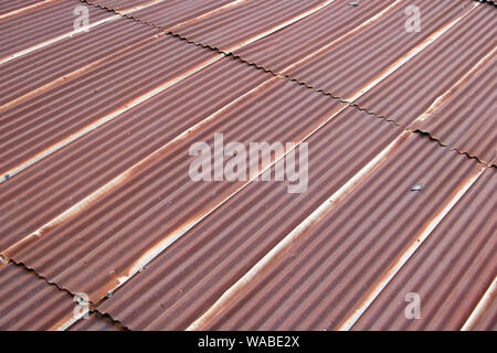 Ein rotes Wellblechdach diagonal anzeigen. Zinn Platten auf dem Dach des Gebäudes. Stockfoto