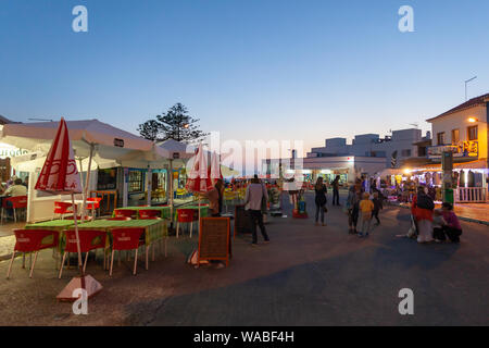 Touristen genießen den warmen Sommerabend in Zambujeira do Mar, einer Küstenstadt an der Atlantikküste in Alentejo, Portugal. Stockfoto