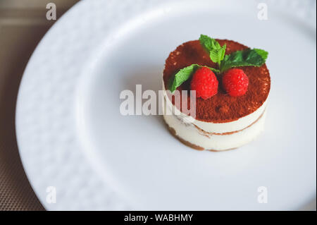 Kochen italienische Küche Dessert Tiramisu, mit allen nötigen Zutaten Kakao, Kaffee, Mascarpone, Minze und Himbeeren. Dessert Tiramisu Stockfoto