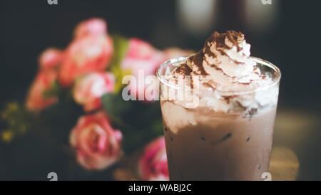 Chocolate frappe mit Schlagsahne, Sirup und Cookies. Vintage Shop Hintergrund Stockfoto