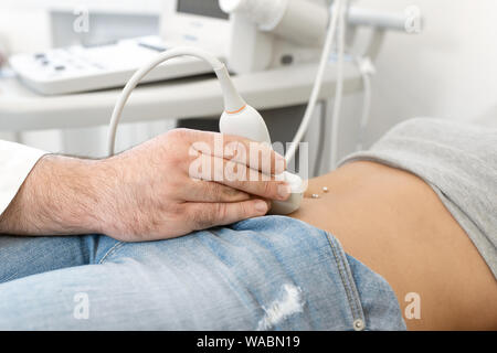 Junge Frau in 4D Ultraschall. Die Ultraschalldiagnostik, die Untersuchung des Abdomens. Stockfoto