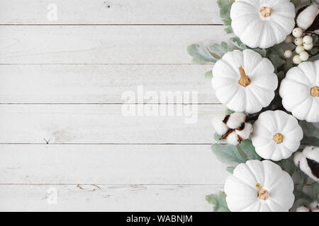 Herbst Seite Grenze von Weiß Kürbisse und silbernen Blätter über eine rustikale weiß Holz Hintergrund Stockfoto