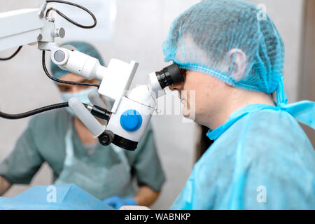 Augenarzt Chirurg durch OP-Mikroskop schwer tun. Stockfoto