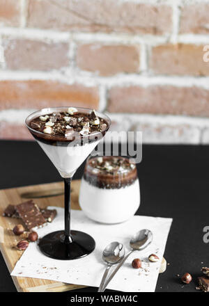 Dessert, Milch Schokolade Gelee mit gehackte Schokolade und Nüssen. transparente Gläser mit Schokolade Panna cotta oder Bird's Milch Nachtisch. Stockfoto