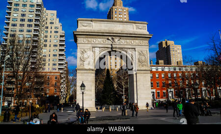 New York City, USA, 2. Januar 2015, berühmte Triumphpforte Steinbogen von vielen Menschen die Sonne genießen in der öffentlichkeit Washington Square Park umgeben. Stockfoto