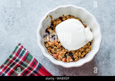 Crumble mit frischen Beeren und Vanille Eis. Organische Dessert. Stockfoto