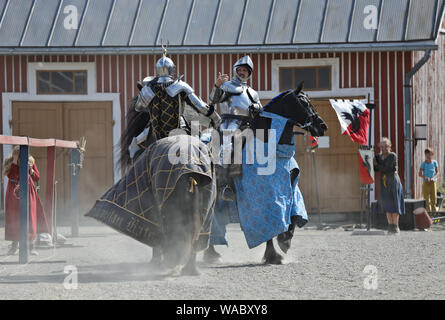 Hameenlinna Finnland 08/17/2019 mittelalterliches Fest mit Handwerker, Ritter und Animateure. Zwei Ritter kämpfen für eine Frau auf dem Pferd Stockfoto