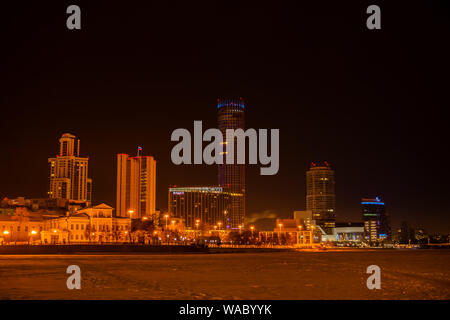 Jekaterinburg, Russland - Januar 16, 2019: Nacht winter Stadt Landschaft und Aussicht des Iset Turm von der Waterfront der Stadt Teich Stockfoto