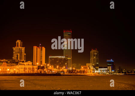 Jekaterinburg, Russland - Januar 16, 2019: Nacht winter Stadt Landschaft und Aussicht des Iset Turm von der Waterfront der Stadt Teich Stockfoto