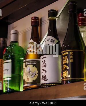 Shanghai, China - Dec 12, 2015: Kamotsuru Itteki Nyukon Sake und Tanqueray Gin Flaschen auf Holz Regal Stockfoto