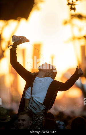 Mädchen Trinkwasser beim Tanzen auf dem Glastonbury Festival 2019 in Pilton, Somerset Stockfoto