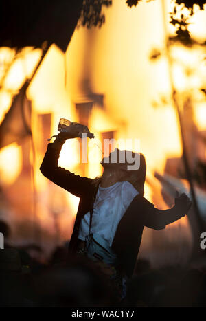 Mädchen Trinkwasser beim Tanzen auf dem Glastonbury Festival 2019 in Pilton, Somerset Stockfoto