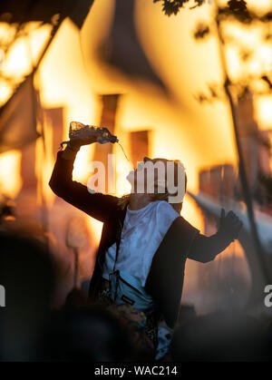 Mädchen Trinkwasser beim Tanzen auf dem Glastonbury Festival 2019 in Pilton, Somerset Stockfoto