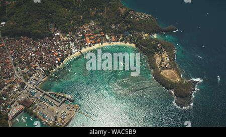 Antenne Draufsicht auf Crystal Ocean Bay, das Dorf und die Grünen Wald Berge. Vulkan im Hintergrund. Reise Urlaub Paradies Tourismus Konzept. Tropische Insel Bali, Indonesien Stockfoto