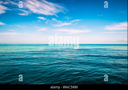 Unendlichen Horizont mit trübe weiße tropische Wolken über Bands der tropischen blauen Meer leer Stockfoto