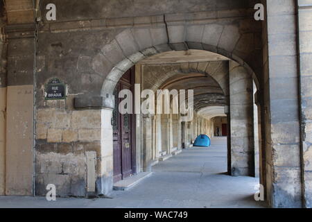 Städtische Armut, Zelt unter den Bögen der Place des Vosges im Marais-Viertel von Paris. Stockfoto