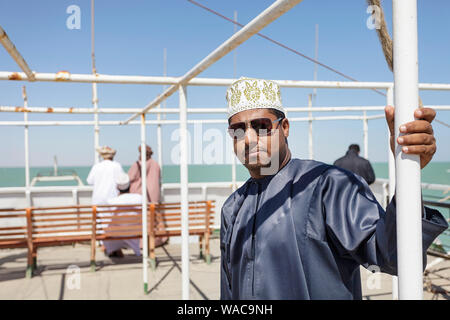 Lokaler Mann in traditioneller Kleidung auf dem Auto Fähre nach Masirah Island, Oman Stockfoto
