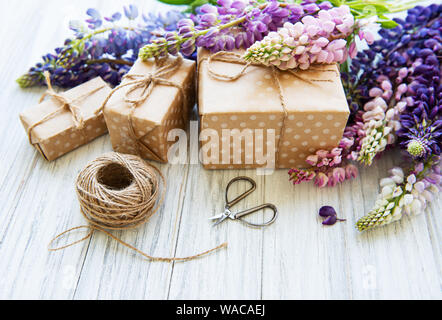 Lupine Blumen auf weißem Hintergrund und Geschenkboxen aus Holz Stockfoto