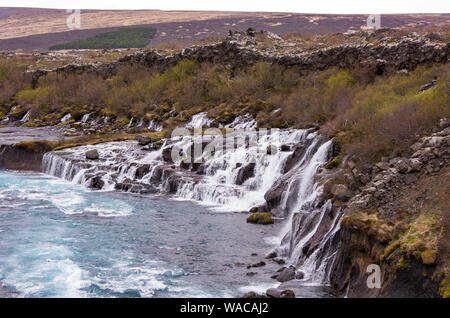 HUSAFELL, ISLAND - Wasserfall Hraunfossar, die aus Lava Feld. Stockfoto