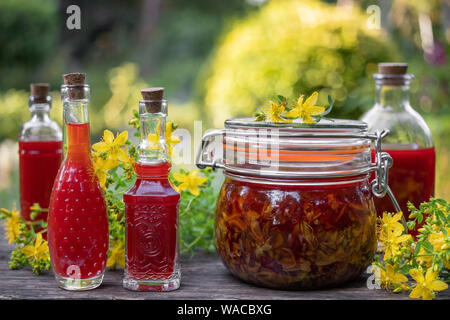 Flaschen Öl aus Johanniskraut Blüten erfolgen, im Freien Stockfoto