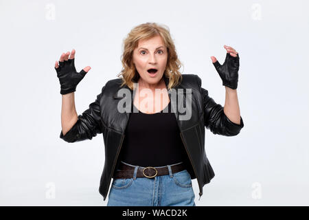 Überrascht Frau in Schwarz Jacke schrie aufgeregt wird. Stockfoto