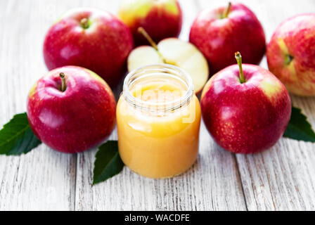 Apfelmus im Glas Glas und frische Äpfel auf einem Holztisch Stockfoto