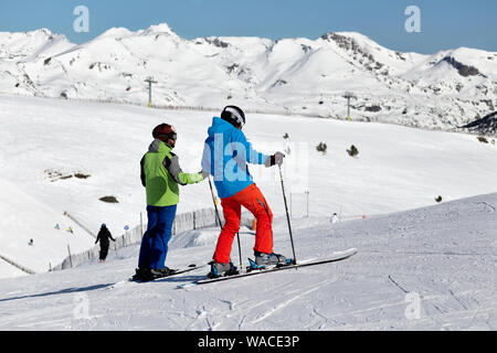 Pyrenäen, ANDORRA - Februar 13, 2019: Zwei unbekannte Skifahrer auf der Seite eines Berges. Sonnigen Wintertag, Skipiste im Hintergrund Stockfoto