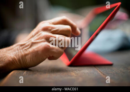 Hände einer reifen Frau mit einem digitalen Tablet. Stockfoto