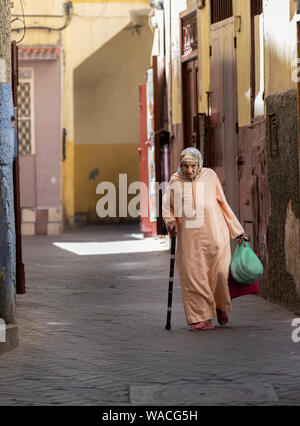 Alte lokale Frau ist zu Fuß auf der Straße mit Taschen. Tanger Stockfoto