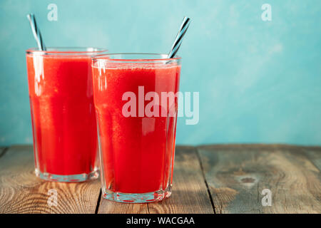 Wassermelone Slushie mit Limette und Minze, sommerlicher erfrischender Drink in hohen Gläsern auf hellblauem Hintergrund. Süßer, kalter Smoothie mit Kopierplatz Stockfoto