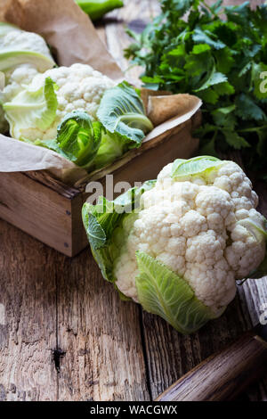 Frische organische homegrown Blumenkohl in Holzkiste, vegane Mahlzeit, auf Basis pflanzlicher Lebensmittel, Nahaufnahme, selektiver Fokus Stockfoto