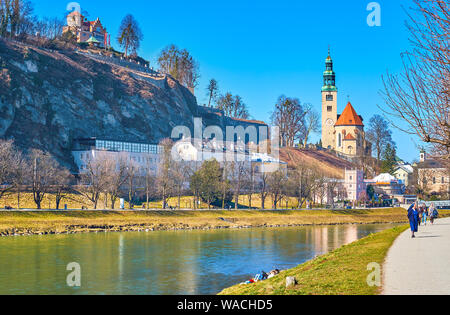 SALZBURG, Österreich - 27. FEBRUAR 2019: Das Ufer der Salzach ist der beste Ort zum Wandern oder ruht auf dem Gras, am 27. Februar in Salzbu Stockfoto