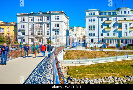 SALZBURG, Österreich - 27. FEBRUAR 2019: Fußgänger entlang der Makartsteg, mit zahlreichen farbigen Liebe Schlösser eingerichtet, hängen an Handläufen, am Feb Stockfoto