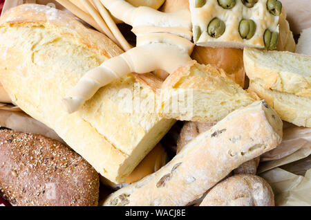 Auswahl an frisch gebackene knusprige Brote und Brötchen mit Ohren auf hölzernen Tisch Hintergrund. Rustikale Vintage Style. Ansicht von oben. Stockfoto