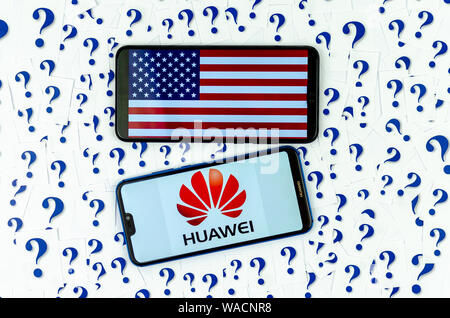 HUAWEI Logo und die amerikanische Flagge auf der Smartphones und eine Menge Papier schneiden Fragezeichen um. Die konzeptuellen Foto über die Zukunft von Huawei in den USA. Stockfoto