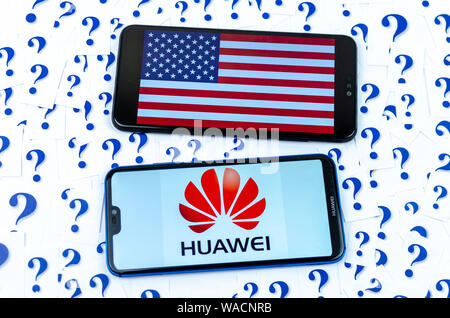 HUAWEI Logo und die amerikanische Flagge auf der Smartphones und eine Menge Papier schneiden Fragezeichen um. Die konzeptuellen Foto über die Zukunft von Huawei in den USA. Stockfoto