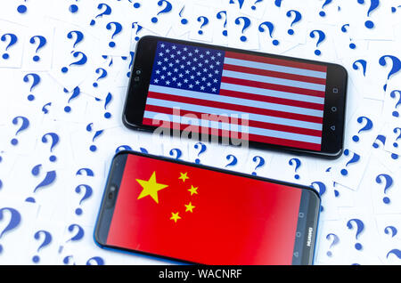 Flagge von Amerika und China auf der Huawei smartphones und eine Menge Fragezeichen um. Die konzeptuellen Foto über Zukunft der uns China Beziehung Stockfoto