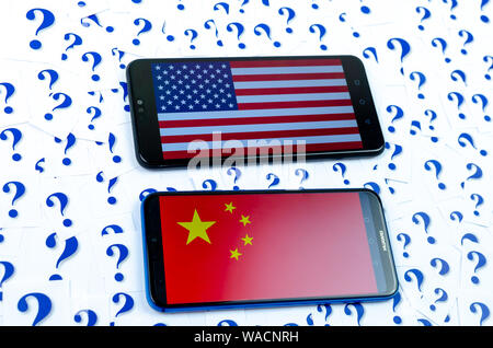 Flagge von Amerika und China auf der Huawei smartphones und eine Menge Fragezeichen um. Die konzeptuellen Foto über Zukunft der uns China Beziehung Stockfoto