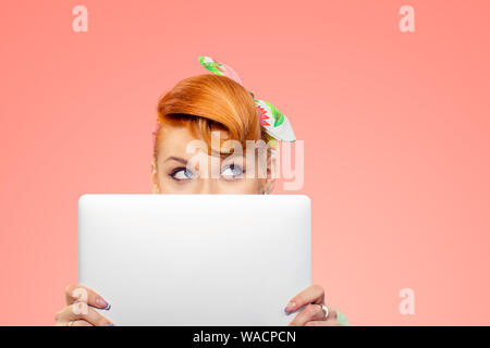 Student versteckt sich hinter Laptop. Closeup Portrait headshot schönen selbstbewussten jungen Geschäftsfrau pinup Girl holding Computer isoliert Pfirsich rosa Farbe Stockfoto