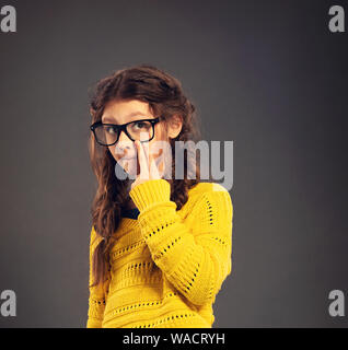 Denken Grimassen Schülerin in Brillen suchen auf Grau studio Hintergrund in Mode Bekleidung. Zurück zu Schule. Der Begriff der Bildung. Closeu Stockfoto