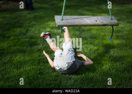 Ein Kind liegt auf dem Boden nach einem Fall aus Holz- Swing Stockfoto