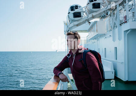 Porträt eines Mannes stehen auf einer Fähre Deck mit Blick auf das Meer Stockfoto