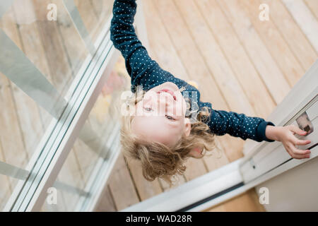 Mädchen in der Tür stehen zu Hause lachend den Kopf nach unten schauen. Stockfoto