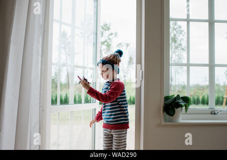 Junge Junge spielt mit dem Flugzeug in der Tür zu Hause Stockfoto