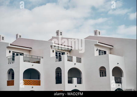 Modernes Gebäude mit weißen Wänden und großen Balkonen gegen bewölkter Himmel entfernt auf der Straße auf Teneriffa Stockfoto