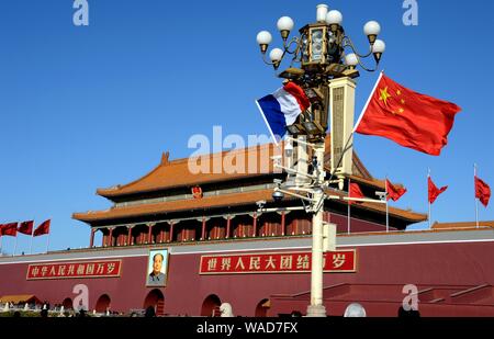 ------ Chinesische und Französische Nationale Fahnen flattern auf einen Laternenpfahl vor dem Tian'anmen Podium während des Besuchs des französischen Präsidenten Emmanuel Makro Stockfoto