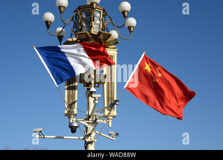 ------ Chinesische und Französische Nationale Fahnen flattern auf einen Laternenpfahl vor dem Tian'anmen Podium während des Besuchs des französischen Präsidenten Emmanuel Makro Stockfoto